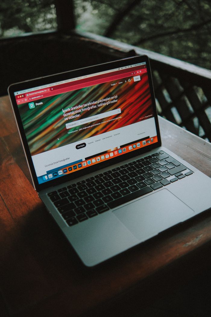 who-we-are A close-up view of a laptop with a website open, placed on a wooden table near a window.